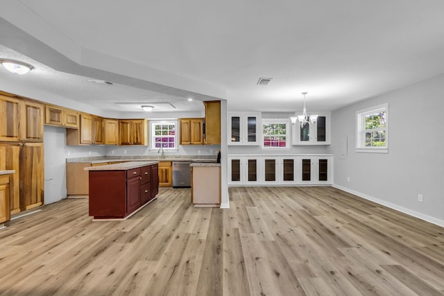 10650 Forest Creek Dr, Conroe, TX 77318 - kitchen with dishwasher, light wood-type flooring, a chandelier, a center island, and brown cabinets