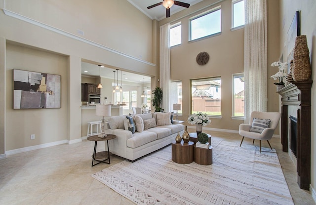 5719 Avon Landing Ln, Sugar Land, TX 77479 - living room featuring plenty of natural light, ornamental molding, a high ceiling, a fireplace, and ceiling fan
