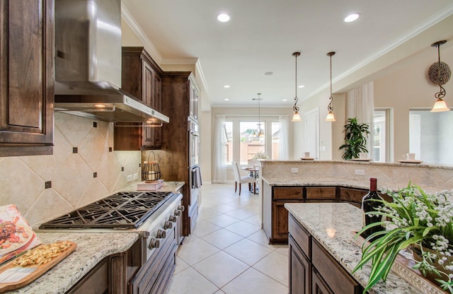 5719 Avon Landing Ln, Sugar Land, TX 77479 - kitchen with wall chimney range hood, stainless steel appliances, dark brown cabinetry, light tile patterned flooring, and hanging light fixtures