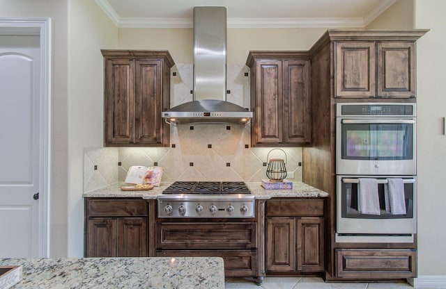 5719 Avon Landing Ln, Sugar Land, TX 77479 - kitchen with wall chimney range hood, appliances with stainless steel finishes, light stone counters, dark brown cabinets, and crown molding