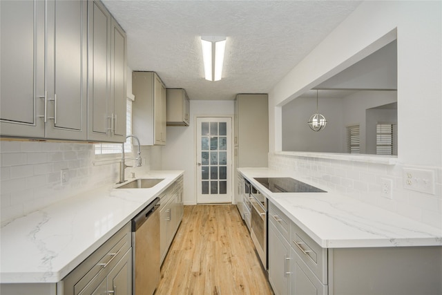 7502 Dawnbriar Ct, Houston, TX 77489 - kitchen with gray cabinets, stainless steel dishwasher, black electric stovetop, light wood finished floors, and a textured ceiling