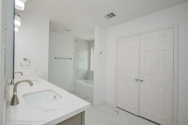 7502 Dawnbriar Ct, Houston, TX 77489 - full bathroom featuring marble look tiles, double vanity, and a textured ceiling