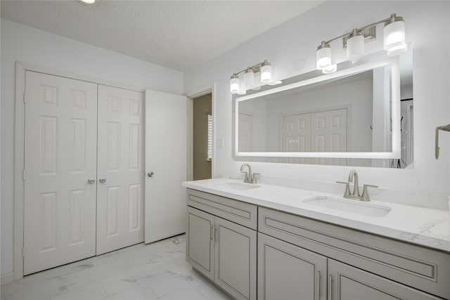 7502 Dawnbriar Ct, Houston, TX 77489 - bathroom featuring double vanity, marble look tile flooring, and a textured ceiling