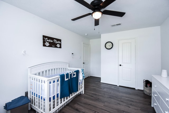 718 River Plantation Dr, Conroe, TX 77302 - bedroom featuring dark wood-type flooring, a nursery area, and a ceiling fan