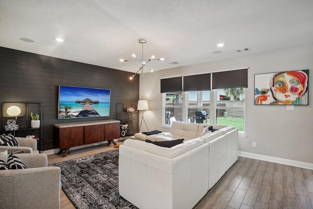 6019 Rivergrove Bend Dr, Humble, TX 77346 - living area with wood finished floors, a chandelier, recessed lighting, an accent wall, and wooden walls