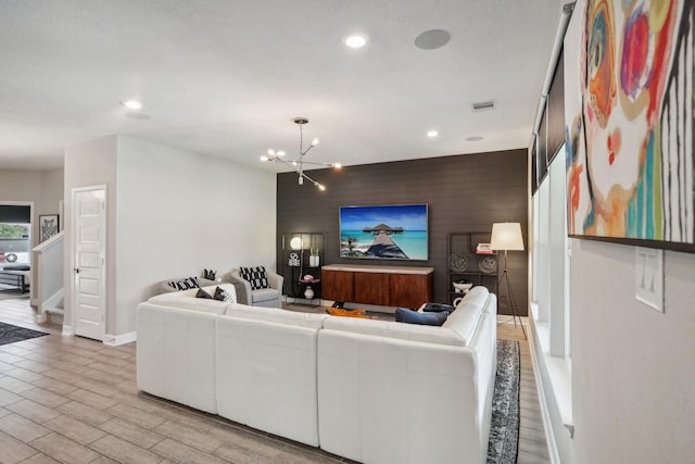 6019 Rivergrove Bend Dr, Humble, TX 77346 - living area featuring an accent wall, recessed lighting, a chandelier, and light wood-type flooring