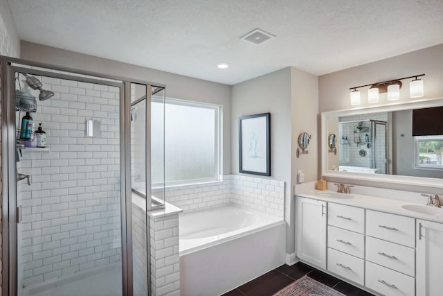 6019 Rivergrove Bend Dr, Humble, TX 77346 - full bathroom with a shower stall, a bath, double vanity, and a textured ceiling