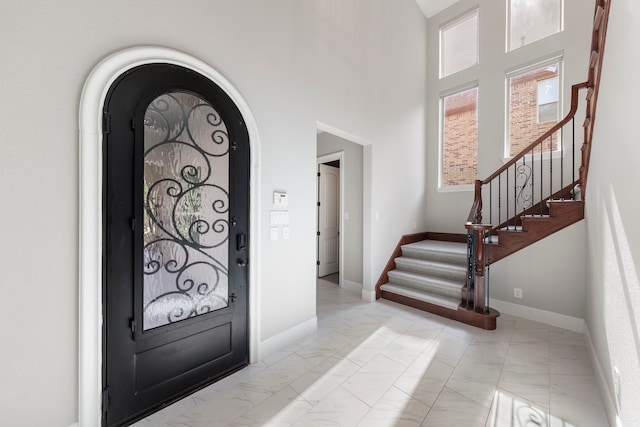 3971 Rolling Thicket Dr, Spring, TX 77386 - foyer featuring light marble finish floors, stairs, and arched walkways