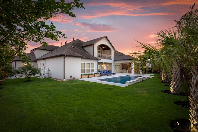 3971 Rolling Thicket Dr, Spring, TX 77386 - back of property at dusk with a lawn, a balcony, an outdoor pool, and an outdoor living space