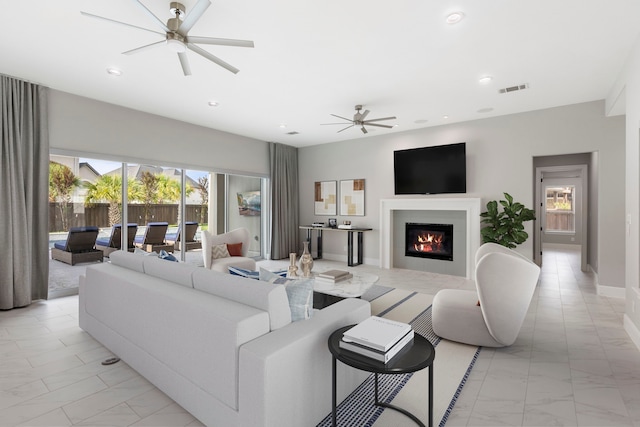 3971 Rolling Thicket Dr, Spring, TX 77386 - living area with ceiling fan, light marble finish floors, a glass covered fireplace, and recessed lighting