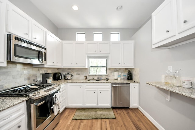 8710 Beverlyhill St Unit 201, Houston, TX 77063 - kitchen with appliances with stainless steel finishes, plenty of natural light, tasteful backsplash, light wood-style flooring, and recessed lighting