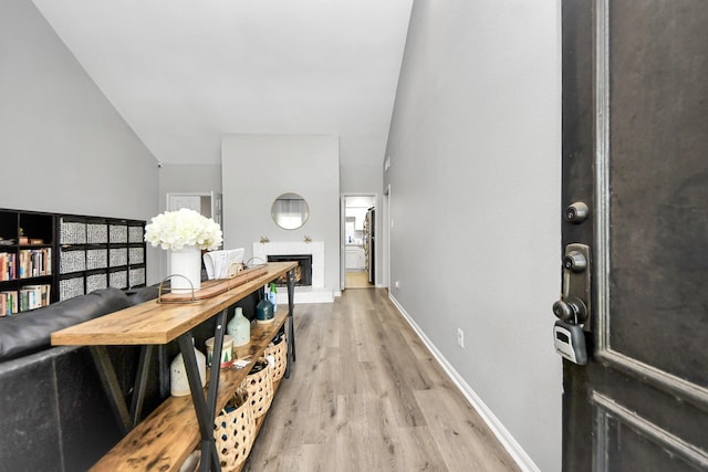 2100 Tanglewilde St Unit 312, Houston, TX 77063 - foyer entrance featuring light wood-style floors and a fireplace with raised hearth