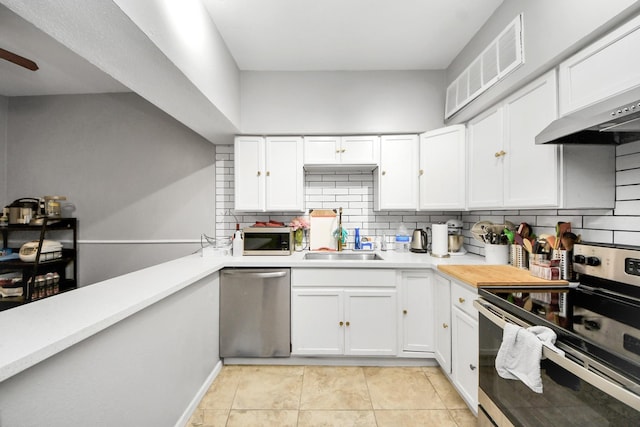 2100 Tanglewilde St Unit 312, Houston, TX 77063 - kitchen featuring appliances with stainless steel finishes, decorative backsplash, white cabinetry, light countertops, and light tile patterned floors