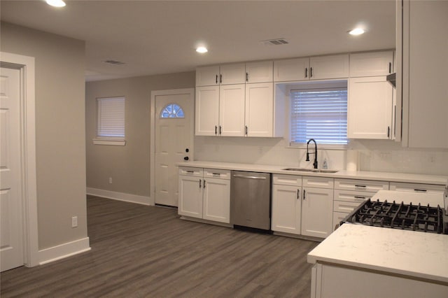 5105 Oak Ave, Pasadena, TX 77503 - kitchen with stainless steel dishwasher, light countertops, white cabinetry, dark wood-type flooring, and tasteful backsplash