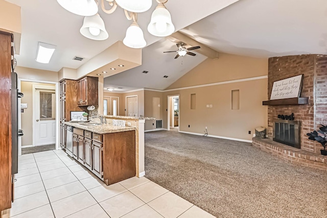 55 Sweetgum Ct, Lake Jackson, TX 77566 - kitchen featuring open floor plan, a ceiling fan, a peninsula, light tile patterned flooring, and a fireplace