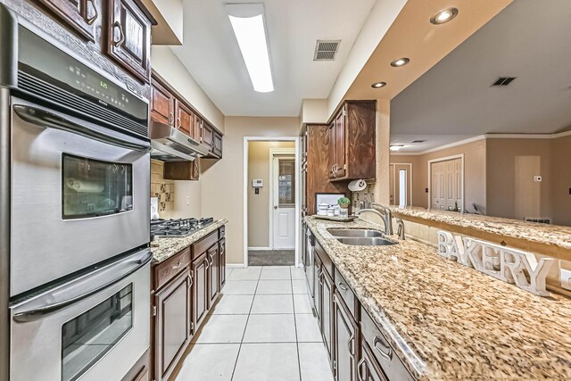 55 Sweetgum Ct, Lake Jackson, TX 77566 - kitchen featuring multiple ovens, light stone countertops, recessed lighting, stainless steel gas cooktop, and light tile patterned floors