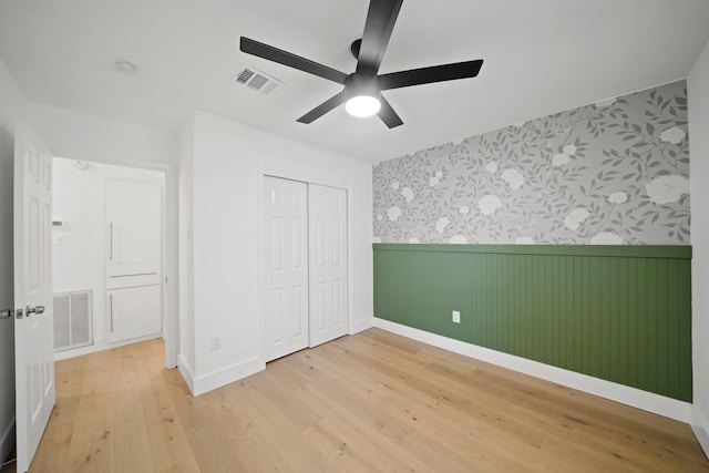 5730 Chrystell Ln, Houston, TX 77092 - unfurnished bedroom featuring wallpapered walls, wainscoting, light wood finished floors, a closet, and ceiling fan