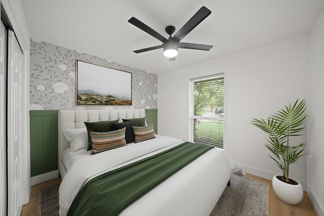 5730 Chrystell Ln, Houston, TX 77092 - bedroom featuring wallpapered walls, wood finished floors, a ceiling fan, and wainscoting