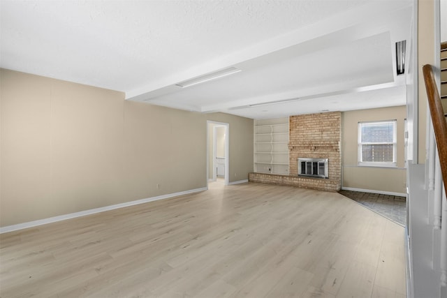 3315 Crestdale Dr, Houston, TX 77080 - unfurnished living room with light wood-type flooring, a brick fireplace, built in shelves, and stairs