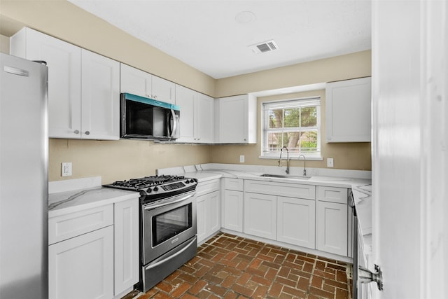 3315 Crestdale Dr, Houston, TX 77080 - kitchen with appliances with stainless steel finishes, brick flooring, and white cabinets