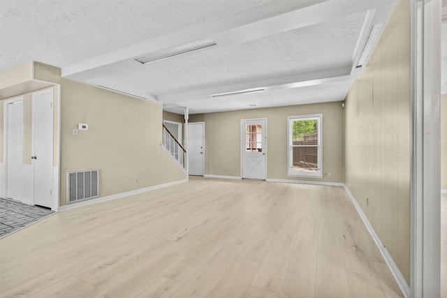 3315 Crestdale Dr, Houston, TX 77080 - unfurnished room featuring a textured ceiling, light wood-style floors, and stairs
