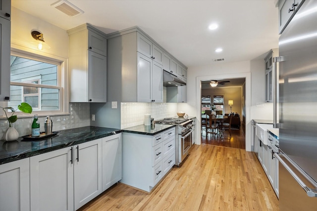 711 Pizer St, Houston, TX 77009 - kitchen with high end appliances, light wood-type flooring, tasteful backsplash, gray cabinets, and recessed lighting