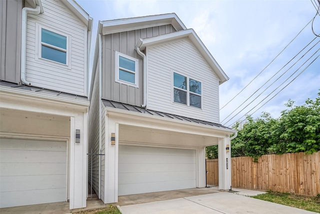 3837 Mainer St, Houston, TX 77021 - view of front facade featuring a garage, board and batten siding, a standing seam roof, and driveway
