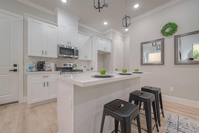 3835 Mainer St, Houston, TX 77021 - kitchen with stainless steel microwave, range, ornamental molding, a breakfast bar, and light wood-type flooring