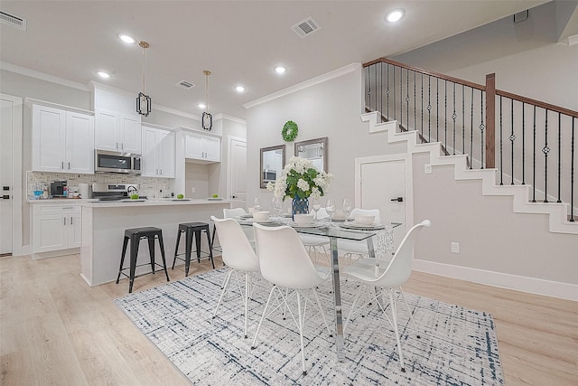 3835 Mainer St, Houston, TX 77021 - dining area with crown molding, light wood finished floors, recessed lighting, and stairway