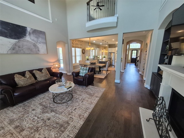 7106 Prairie Grass Ln, Katy, TX 77493 - living area with arched walkways, dark wood-style floors, a chandelier, a towering ceiling, and built in features
