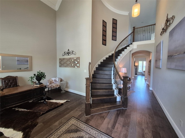 7106 Prairie Grass Ln, Katy, TX 77493 - foyer entrance with arched walkways, a high ceiling, wood finished floors, stairs, and crown molding