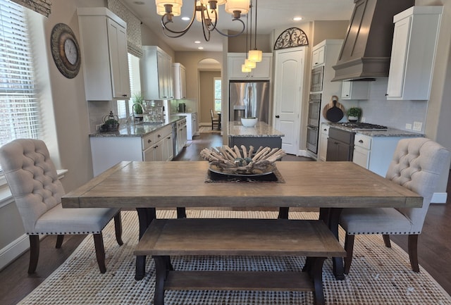 7106 Prairie Grass Ln, Katy, TX 77493 - dining area featuring a chandelier, dark wood-style floors, arched walkways, and recessed lighting