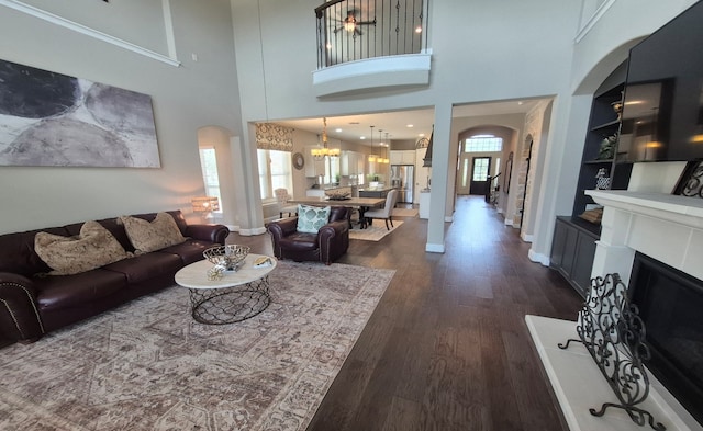 7106 Prairie Grass Ln, Katy, TX 77493 - living room featuring arched walkways, plenty of natural light, dark wood-type flooring, a chandelier, and a towering ceiling