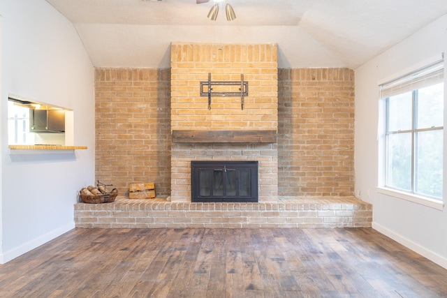 9938 Rustic Rock Rd, La Porte, TX 77571 - unfurnished living room with lofted ceiling, wood finished floors, and a brick fireplace