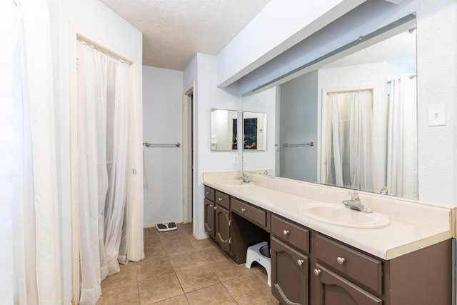 9938 Rustic Rock Rd, La Porte, TX 77571 - bathroom featuring double vanity, tile patterned floors, and a textured ceiling
