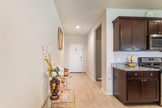 1614 Chase Anchor Ct, Richmond, TX 77469 - kitchen with appliances with stainless steel finishes, light wood-type flooring, dark brown cabinets, and light stone counters