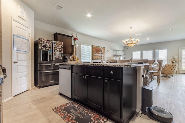 1614 Chase Anchor Ct, Richmond, TX 77469 - kitchen featuring high quality fridge, a chandelier, open floor plan, an island with sink, and light wood finished floors