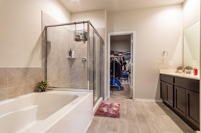 1614 Chase Anchor Ct, Richmond, TX 77469 - full bathroom featuring a stall shower, wood finished floors, vanity, a bath, and a walk in closet