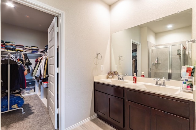 1614 Chase Anchor Ct, Richmond, TX 77469 - full bath with double vanity, a walk in closet, a stall shower, and a textured wall