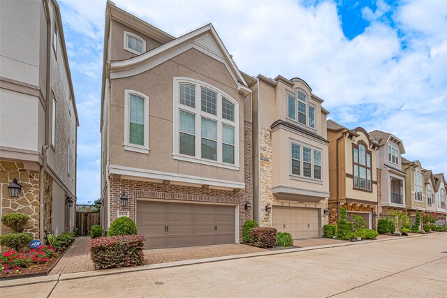 8324 Ginger Oak St, Houston, TX 77055 - townhome / multi-family property with stucco siding, an attached garage, a residential view, and driveway