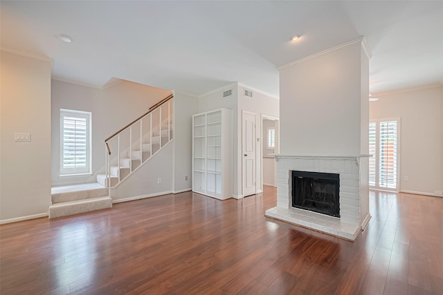 11711 Memorial Dr Unit 213, Houston, TX 77024 - unfurnished living room featuring ornamental molding, stairway, a brick fireplace, and wood finished floors