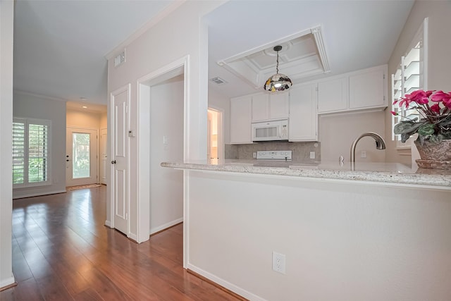 11711 Memorial Dr Unit 213, Houston, TX 77024 - kitchen featuring white microwave, white cabinetry, a peninsula, decorative backsplash, and dark wood-style floors