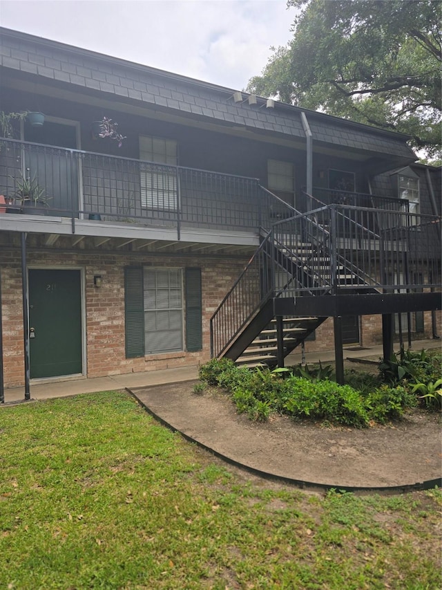 8941 Gaylord St Unit 211, Houston, TX 77024 - back of house featuring stairway, brick siding, and a yard