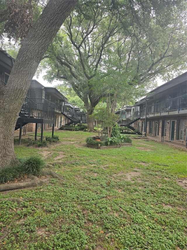 8941 Gaylord St Unit 211, Houston, TX 77024 - view of green lawn featuring stairs and a wooden deck