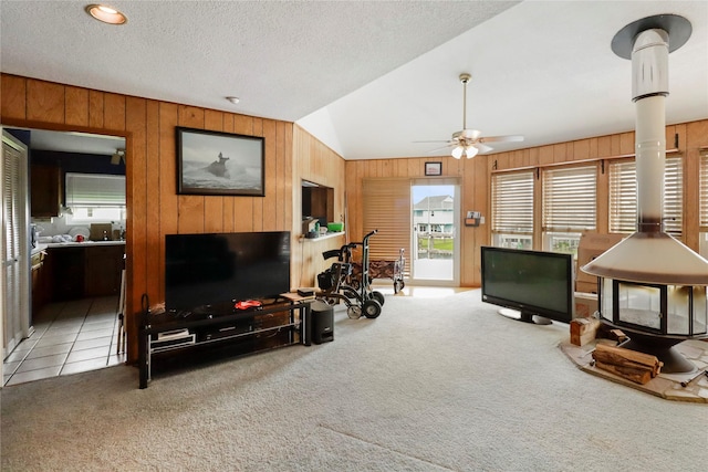 174 Sand Shoals Rd, Freeport, TX 77541 - carpeted living room featuring wood walls, vaulted ceiling, ceiling fan, and a textured ceiling