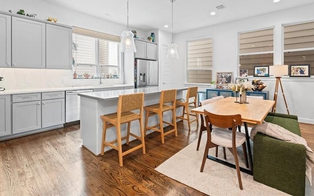 2753 Clinton Dr, Houston, TX 77020 - kitchen with appliances with stainless steel finishes, dark wood-type flooring, gray cabinets, recessed lighting, and light countertops