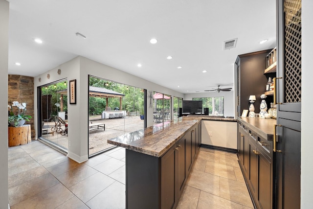 1213 Archley Dr, Hilshire Village, TX 77055 - kitchen with recessed lighting, a peninsula, light tile patterned floors, dark stone counters, and ceiling fan