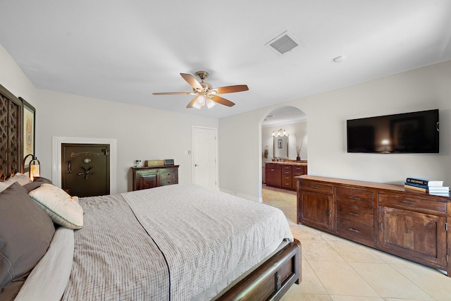 1213 Archley Dr, Hilshire Village, TX 77055 - bedroom featuring light tile patterned floors, arched walkways, a ceiling fan, and connected bathroom