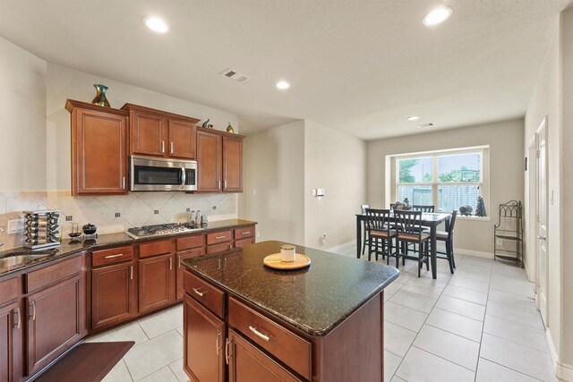 24506 Rossmore Hill Ct, Spring, TX 77389 - kitchen featuring stainless steel appliances, a center island, decorative backsplash, dark stone countertops, and recessed lighting