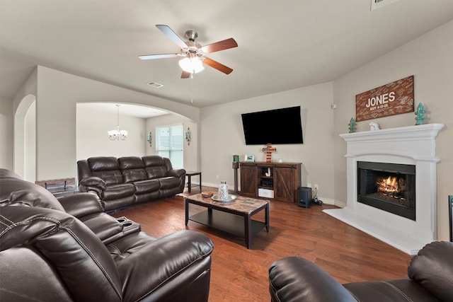 24506 Rossmore Hill Ct, Spring, TX 77389 - living area featuring arched walkways, ceiling fan, wood finished floors, a lit fireplace, and a chandelier
